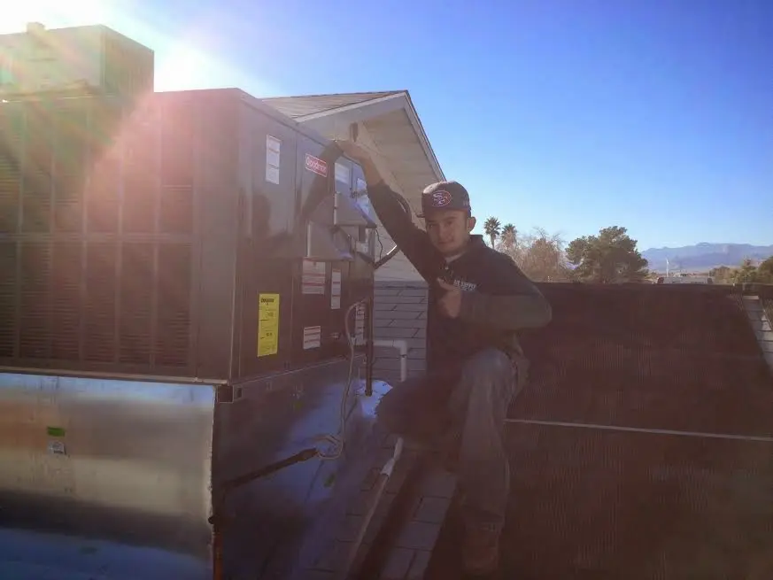 HVAC technician performing Air Duct Repair on a rooftop unit in Lakewood